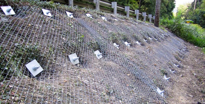 Steel mesh anchored to a slope for rockfall protection