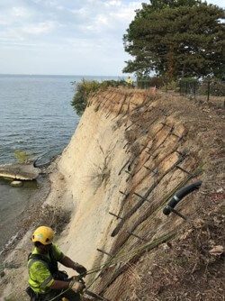 Technician installing stabilization materials on a steep bluff.