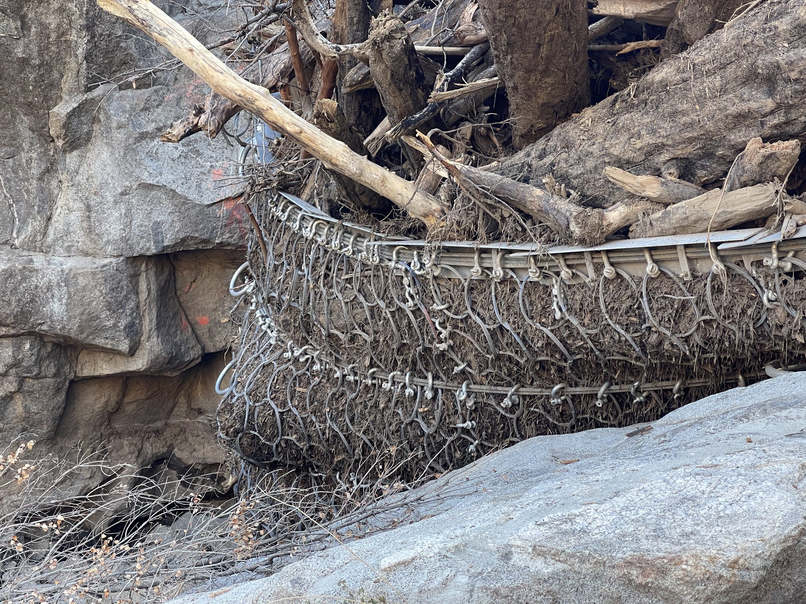 Mesh holding back debris on a rocky slope.