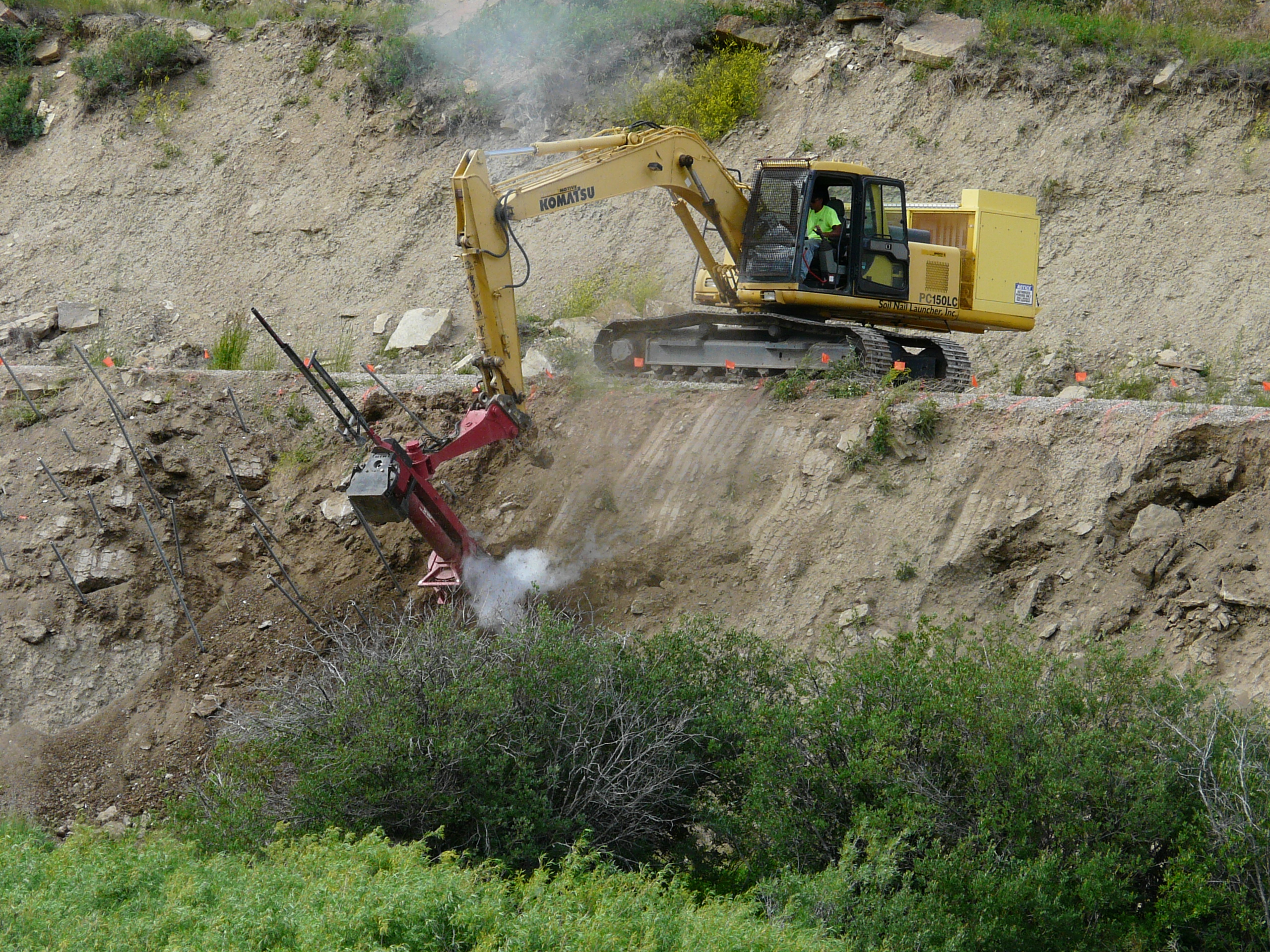 Soil nail launcher to stabilize a steep, eroded slope.