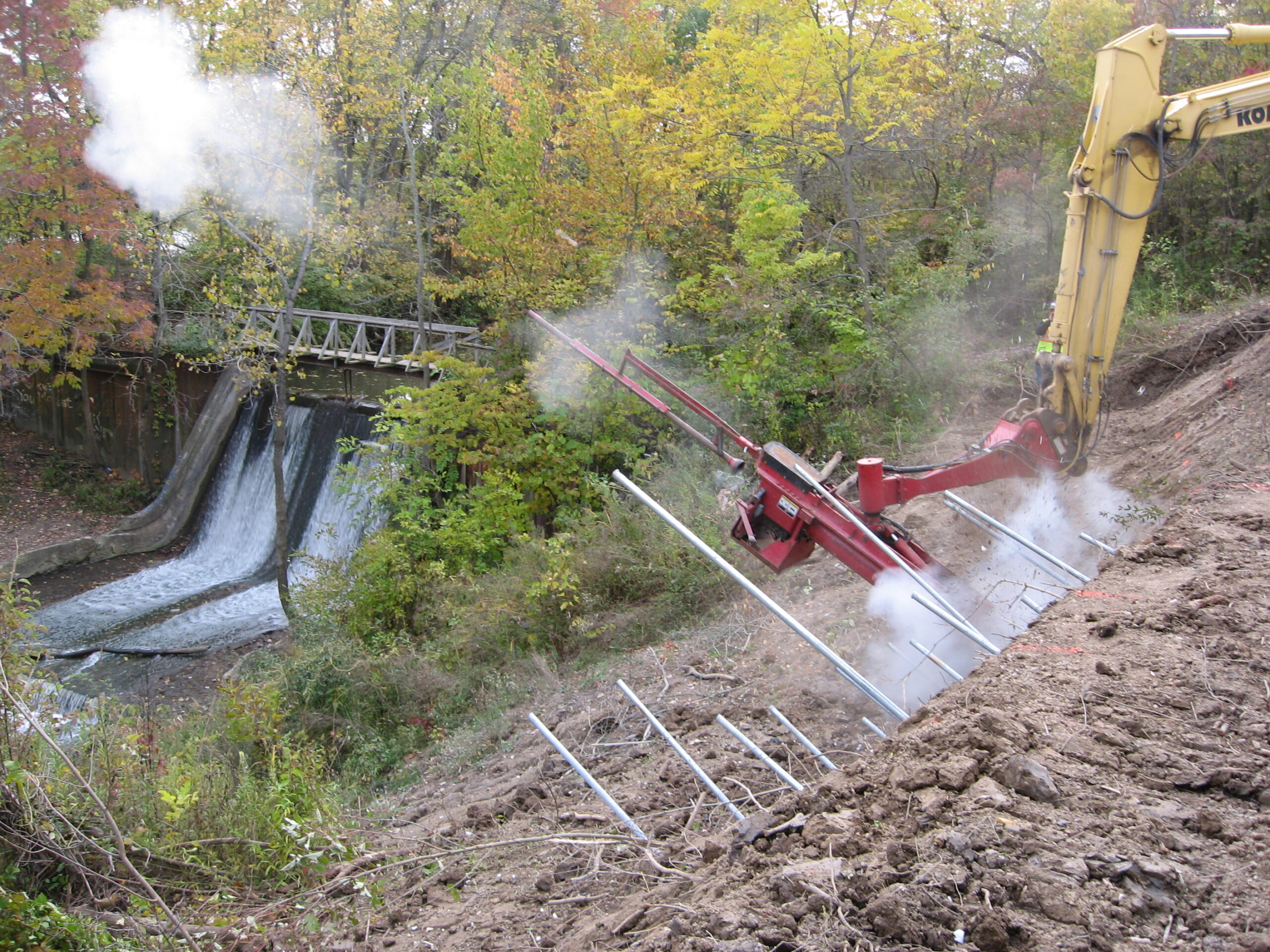 Soil nail launcher installing nails on a steep, vegetated slope.