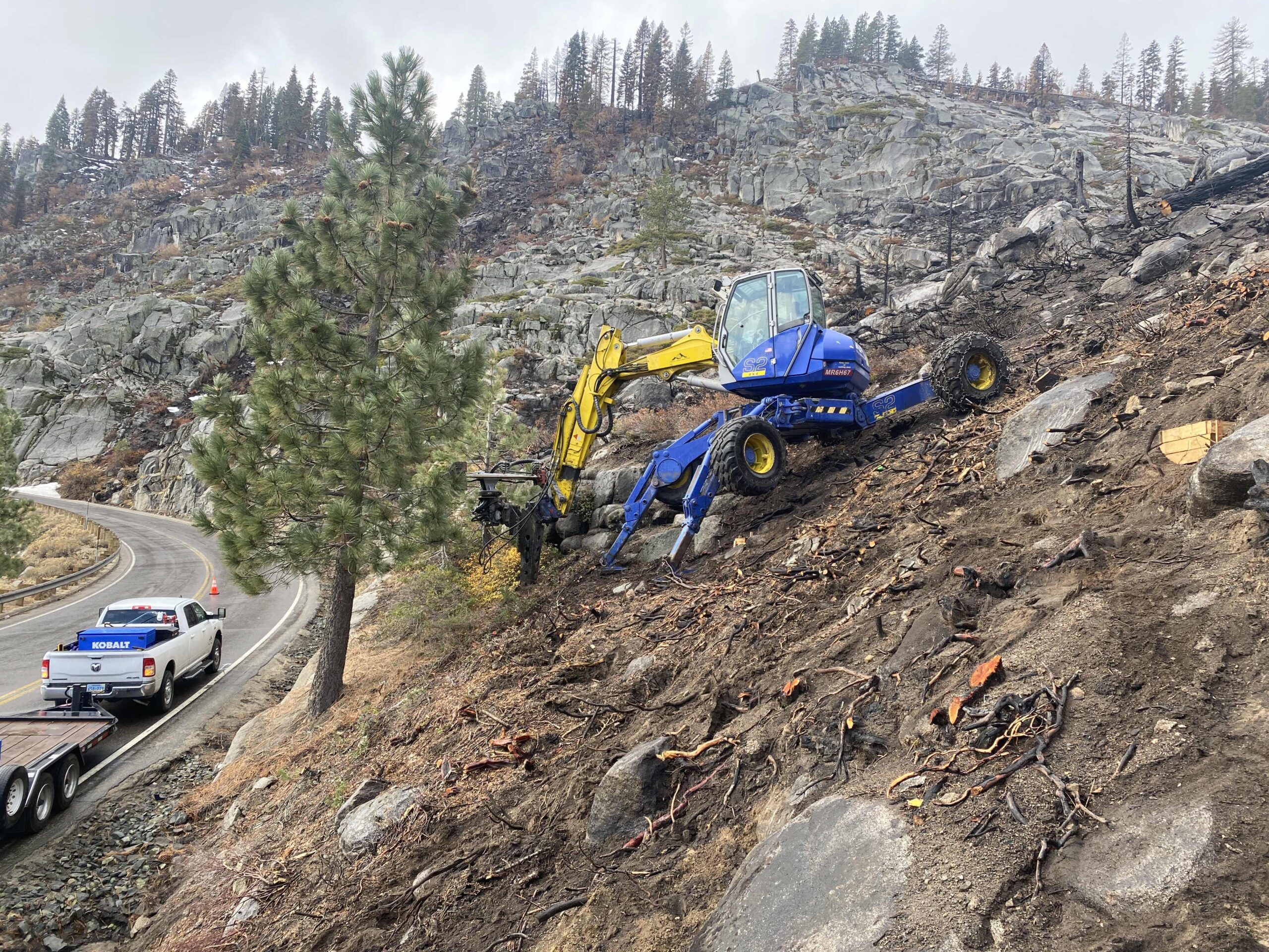 Spider excavator working on slope affected by wildfire