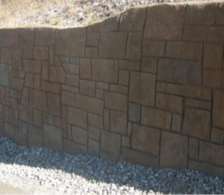 Hand-carved ashlar-patterned shotcrete wall with rich earth-tone staining.