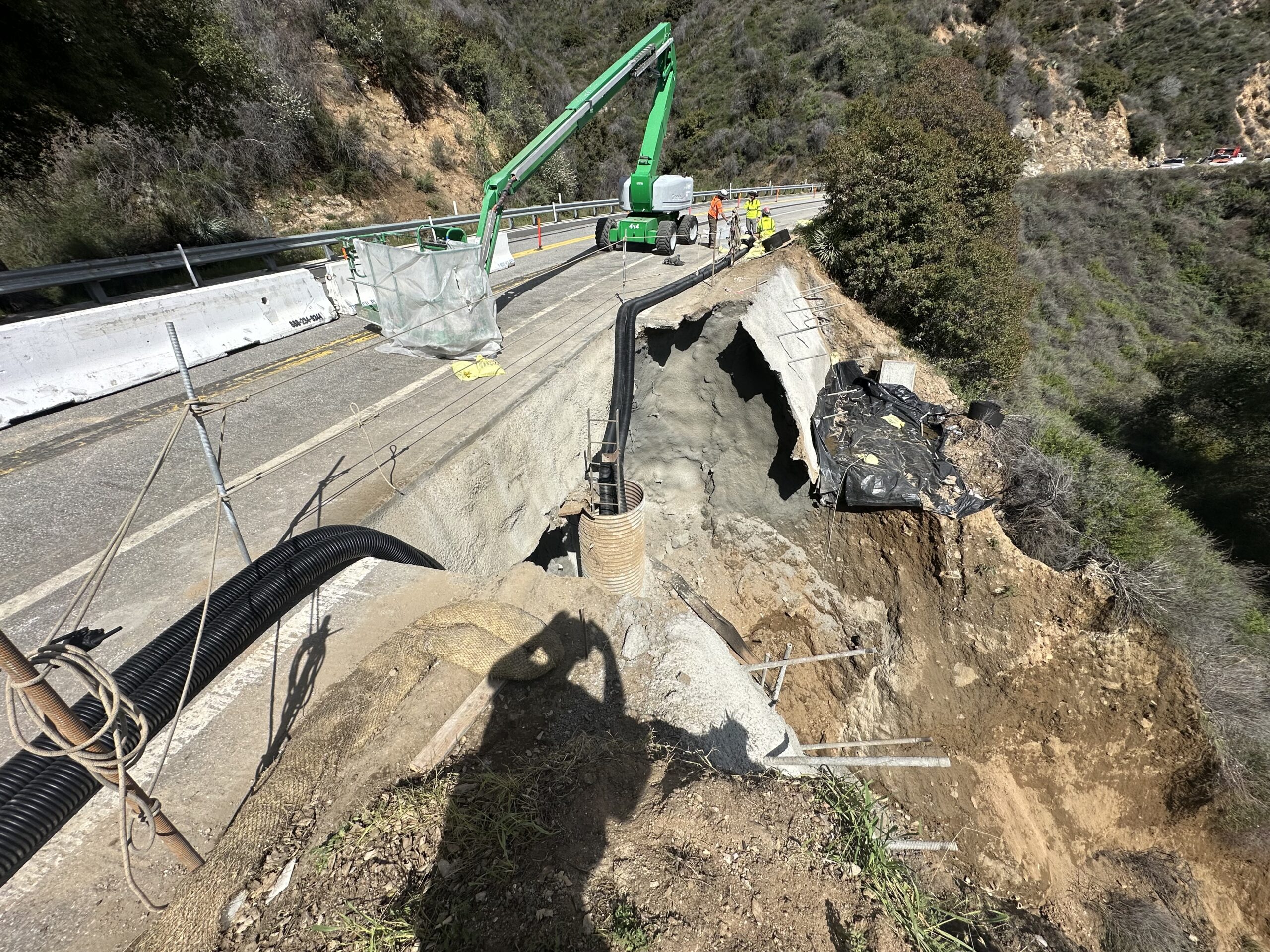 Crew works to stabilize a severely eroded roadside slope.