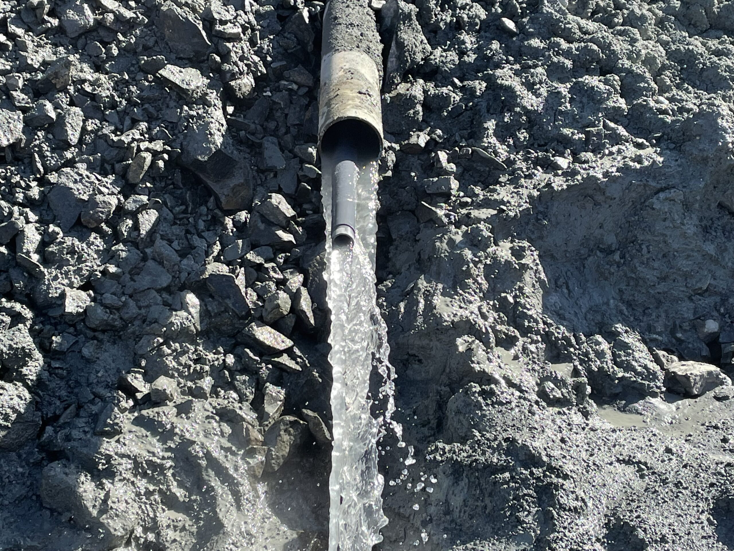 Launched horizontal drain with water draining out.