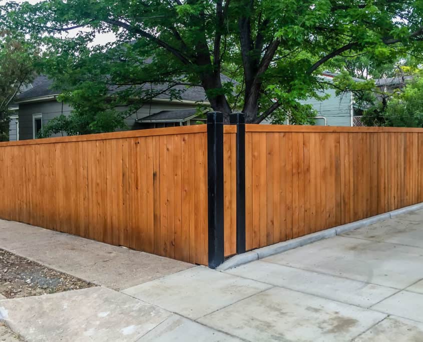Cedar wood privacy fence with black steel posts at residential property corner
