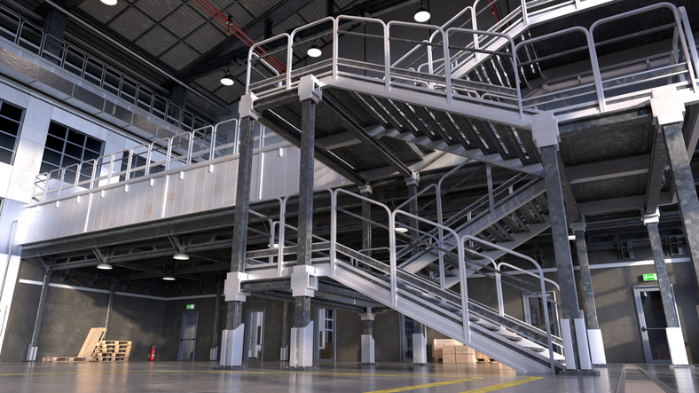 Industrial warehouse interior with steel mezzanine platforms, staircases, and pipe guardrail handrails