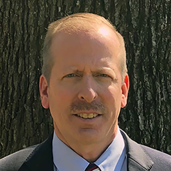 Man smiling in suit.