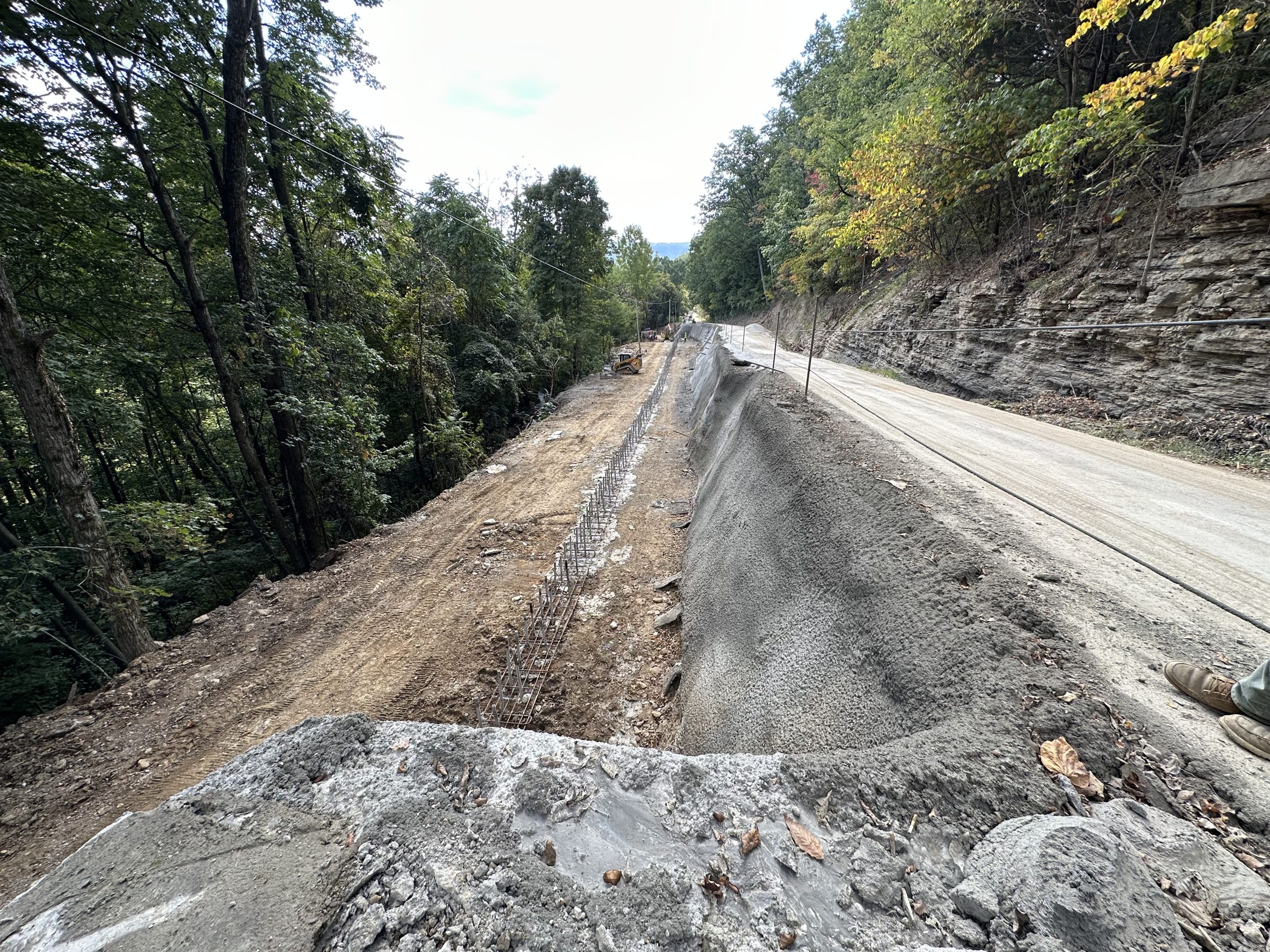 Stabilized roadside slope reinforced with shotcrete, soil nails, and cleared vegetation.