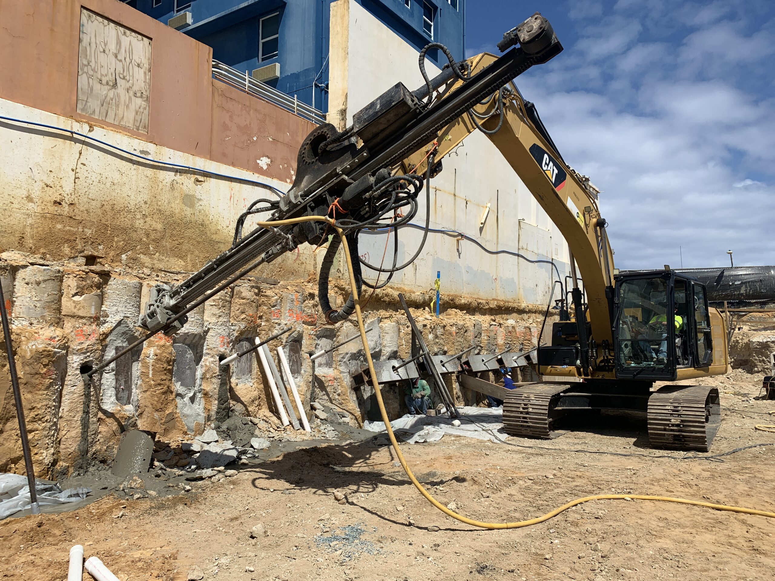 Drill rig working on secant pile wall stabilization.