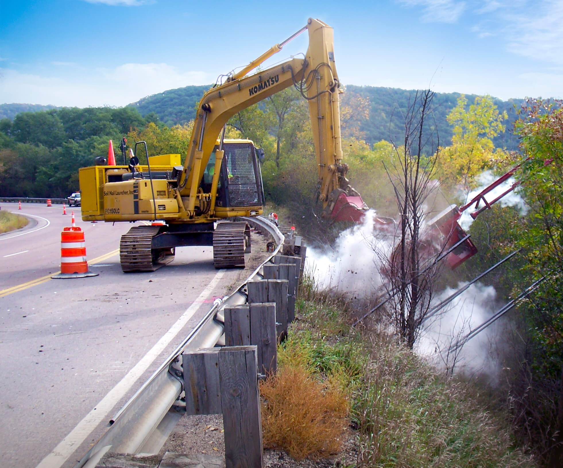 Soil Nail Launcher installing nails on a roadside slope.